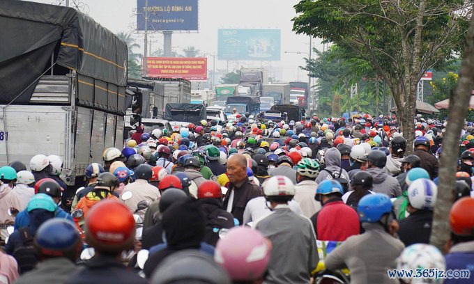 Dòng xe máy, ôtô chen chúc nhau trên quốc lộ 60 qua cầu Rạch Miễu. Ảnh: Thường Sơn